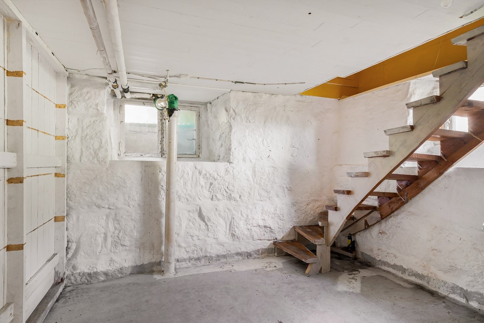 Tretrapp ned til kjelleren, som har betonggulv og yttervegger av gråsteinsmur. Galleribilde