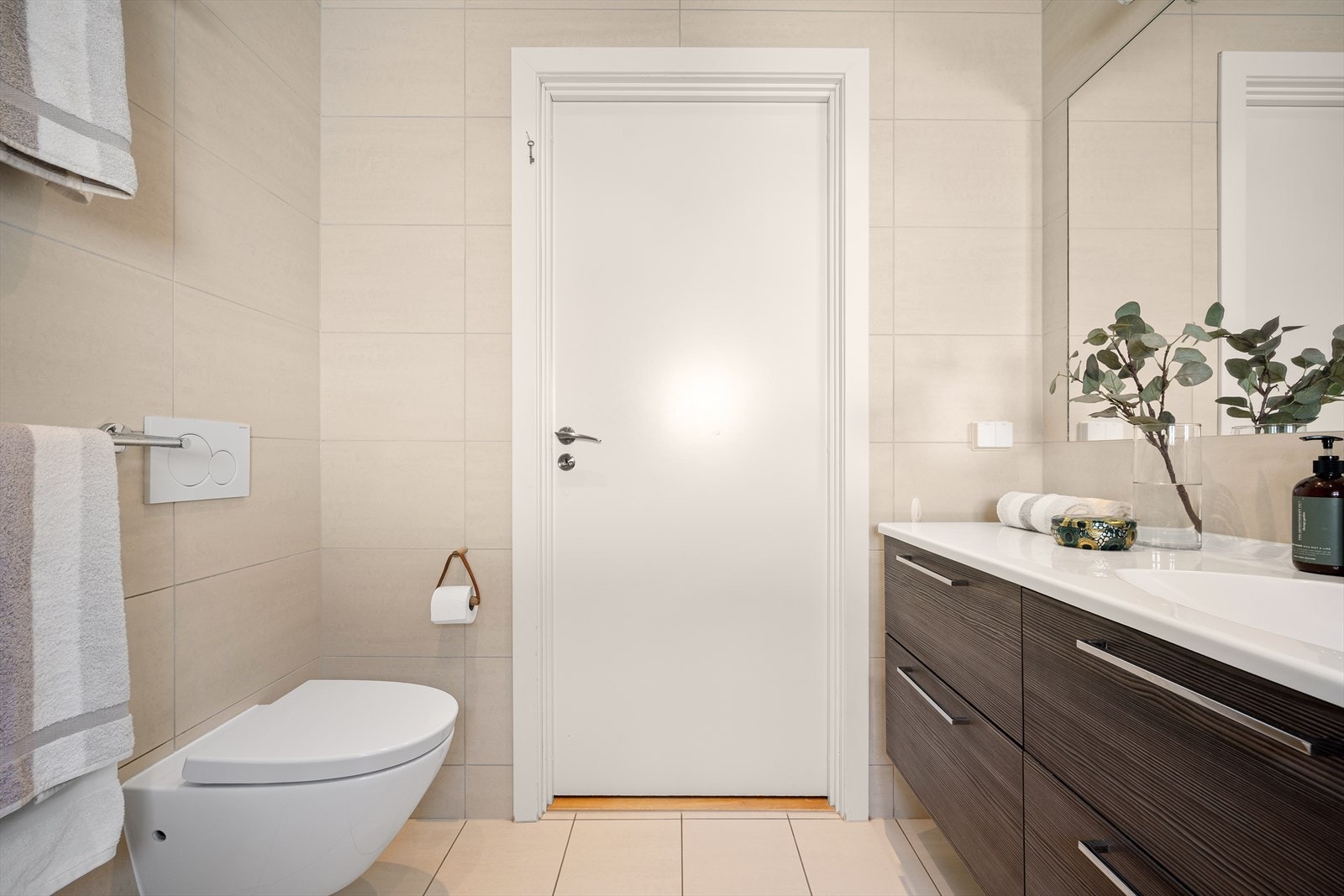 Heldekkende servant med skuffeløsning. Speil innfelt i flis over servant. Lysarmatur over servant. Vegghengt toalett. Malt innvendig tak med downlights. Galleribilde