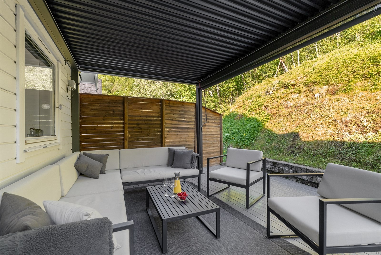 Pergola på ca. 10 m² gir ly og skaper en lun sitteplass. Pergolaveggene er under utbedring, og tre nye vegger følger salget. Galleribilde