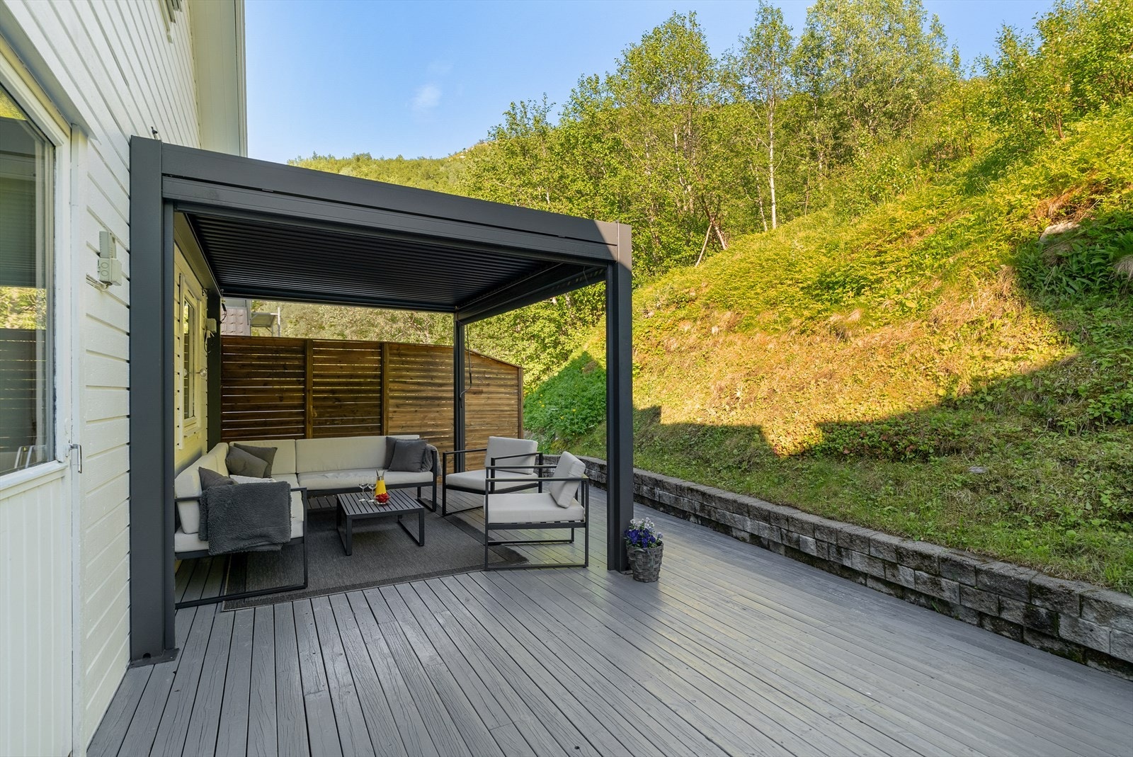 Bak boligen ligger en stor terrasse på ca. 45 m² i trekonstruksjon, bygget i 2002. Galleribilde