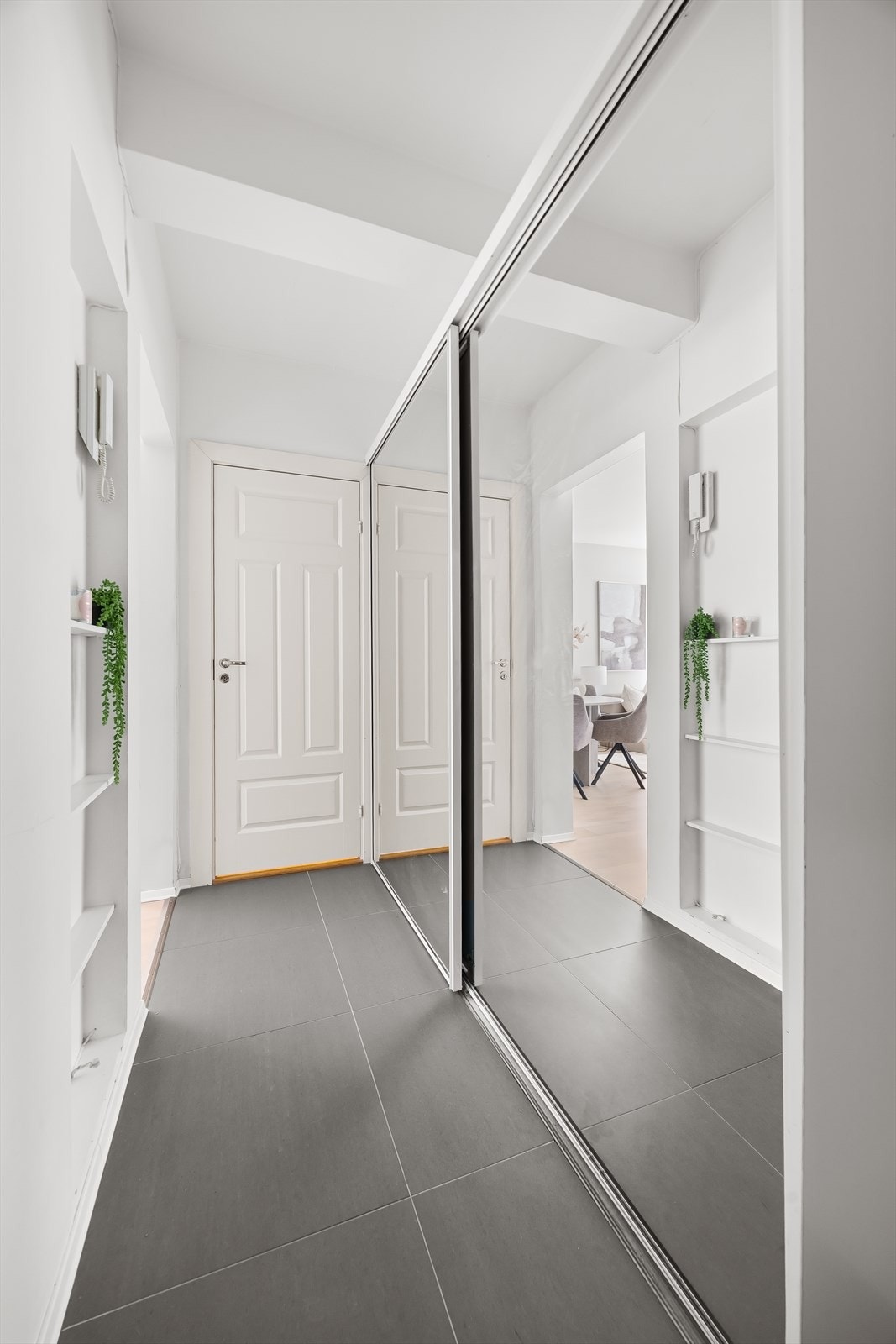 Innbydende entré med porttelefon og stor skyvedørsgarderobe som gir godt med lagringsplass Galleribilde
