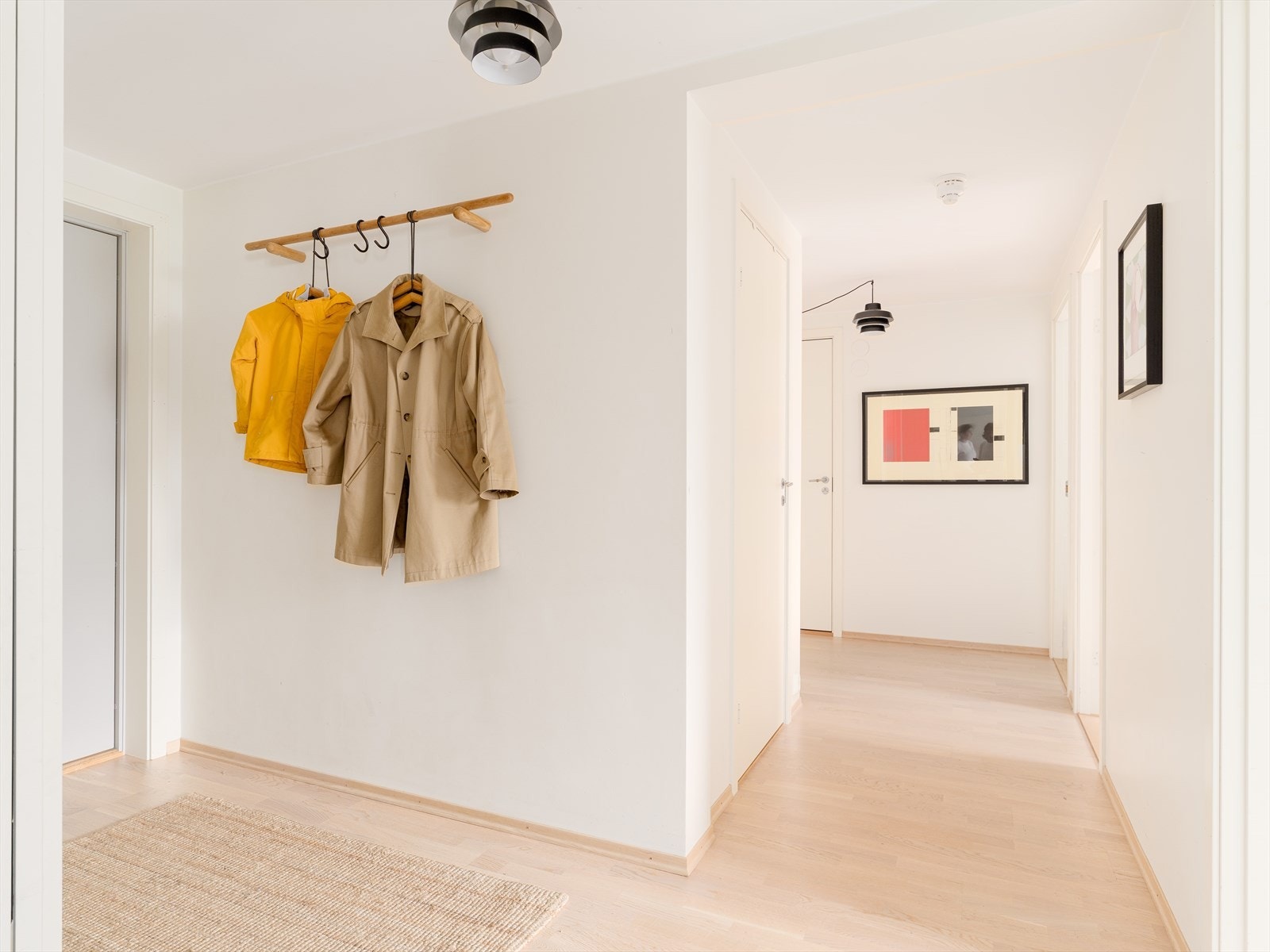 Lys entré og gang med skyvedørsgarderobe og innvendig bod Galleribilde