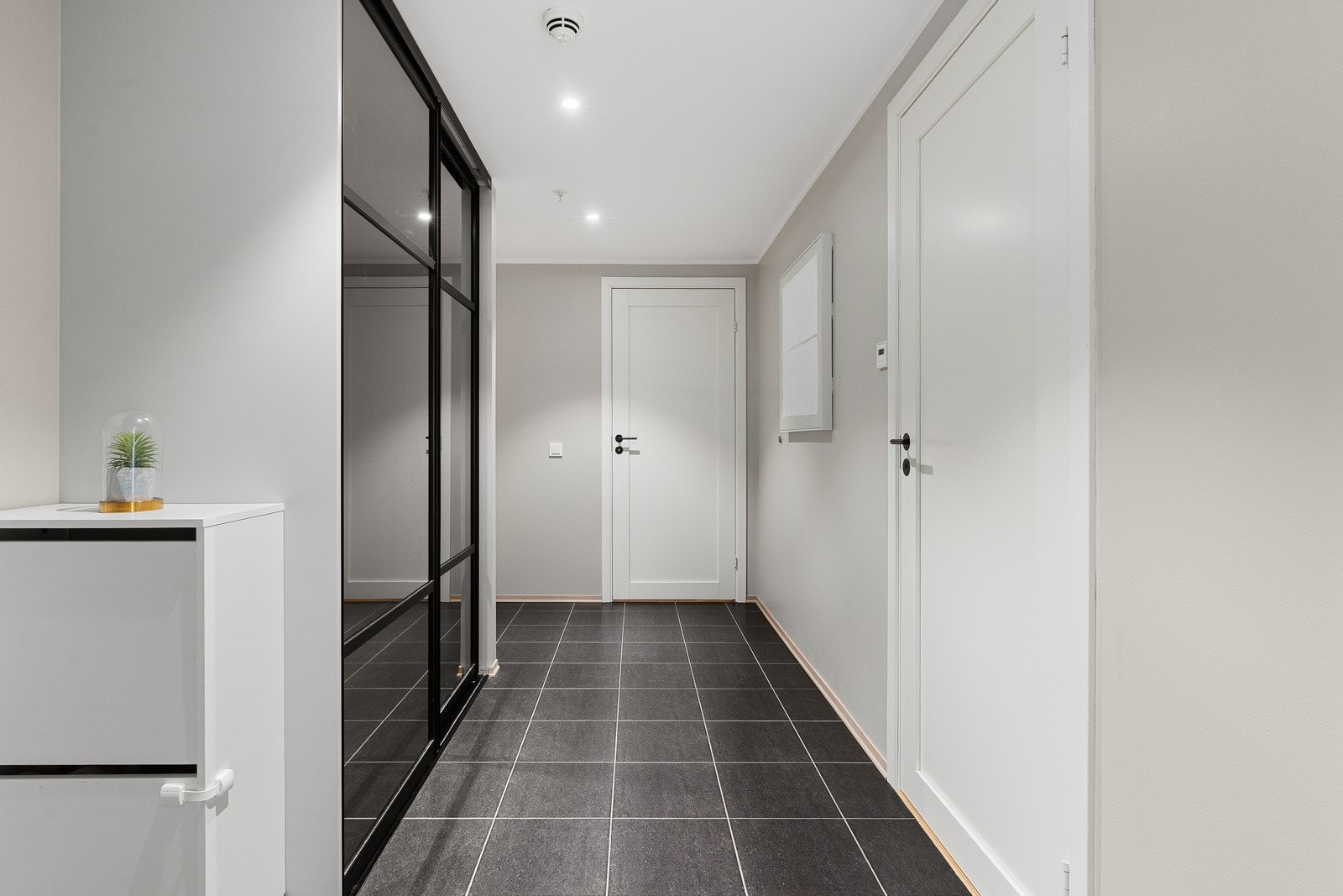 Velkommen inn! Innbydende entré med fliser på gulv og gulvvarme. Stor skyvedørsgarderobe. Galleribilde