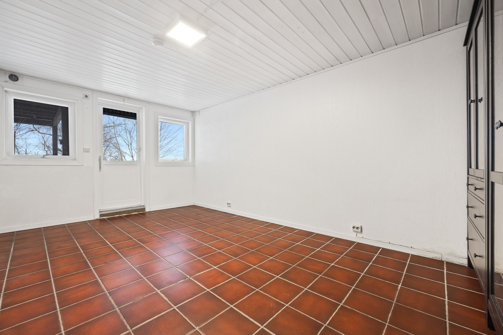 Kjellerstue, evt. soverom 3. Utgang til overbygget terrasse med videre adkomst til hagen Galleribilde