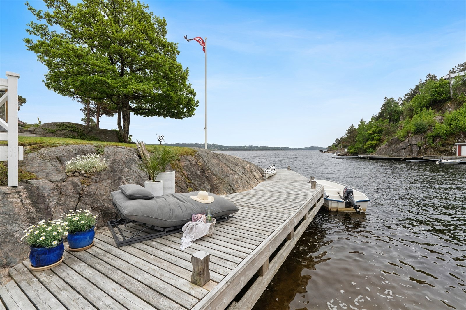 Eiendommen har lang strandlinje, svært solrikt, nydelige uteområder skjermet for vær og vind, stort bryggeanlegg, sjøbu, båthus, strand og anneks Galleribilde