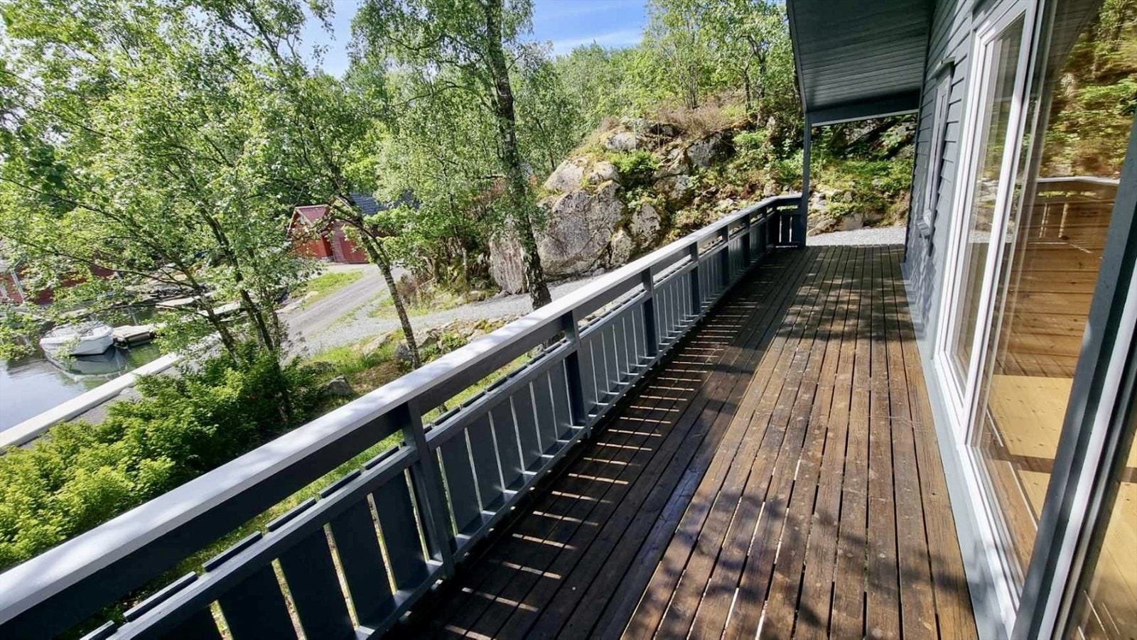 Terrassen strekker seg langs fronten av hytta og fungerer som en naturlig forlengelse av stuen. Her er det god plass til både sittegruppe, grill og annet møblement. Galleribilde