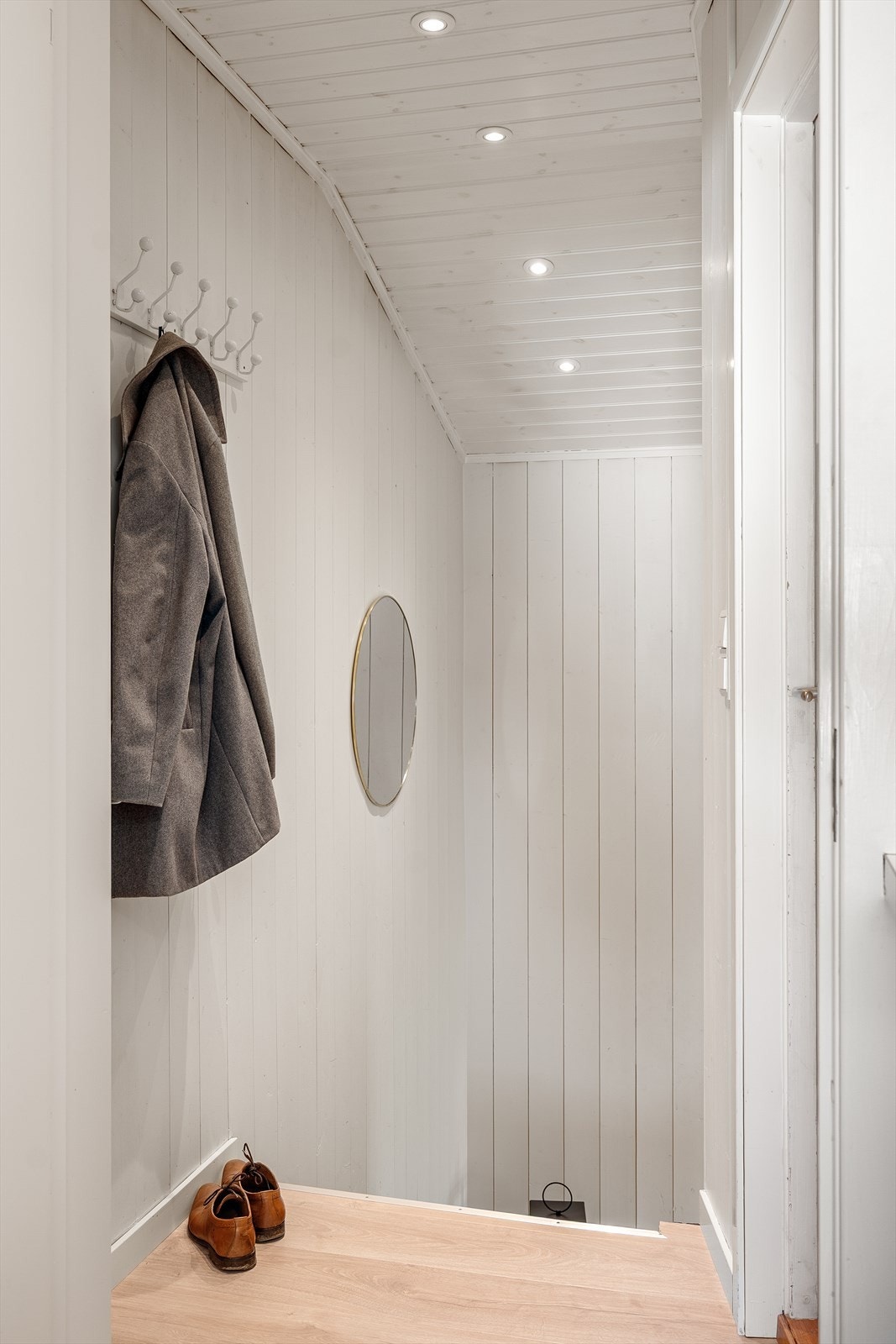 Hoveddelen har egen entré i første etasje. Trappen er effektfullt lyssatt med innfelte spotter og leder mellom entreen og kjøkkenet. Badet til høyre. Galleribilde
