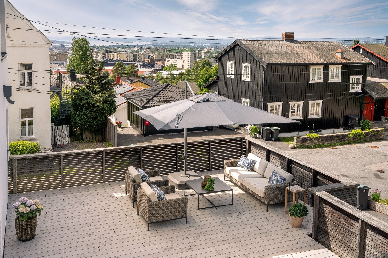 Uteplassen er belagt med en kombinasjon av terrassebord og betong Galleribilde