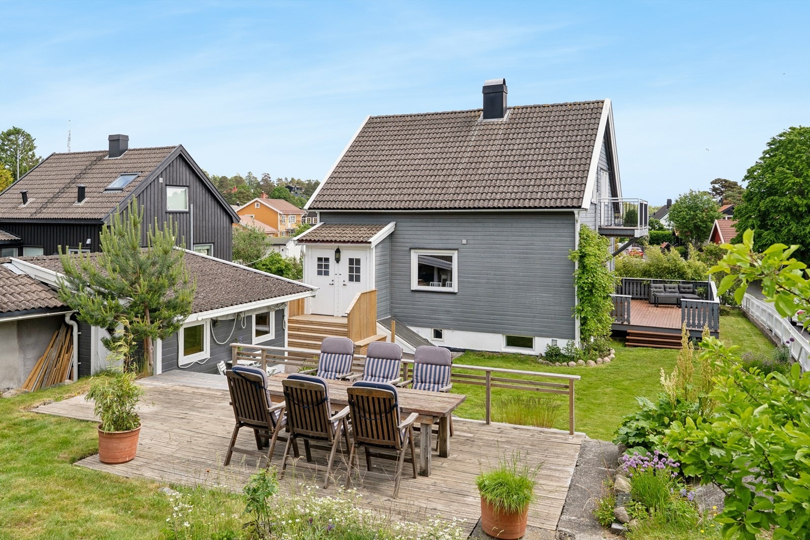 Helhetlig uteområde med solrik treterrasse, sittegruppe og hyggelig hage. Galleribilde