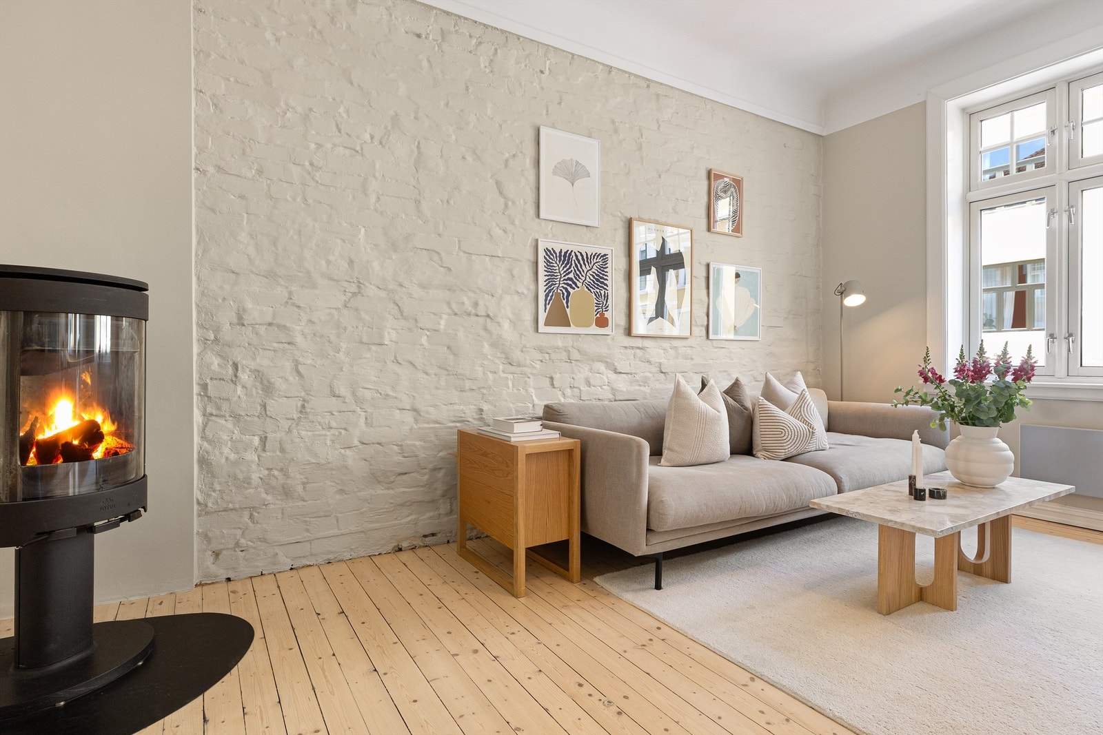 En av veggene i stuen har en malt murstruktur som gir et rustikt preg. Galleribilde