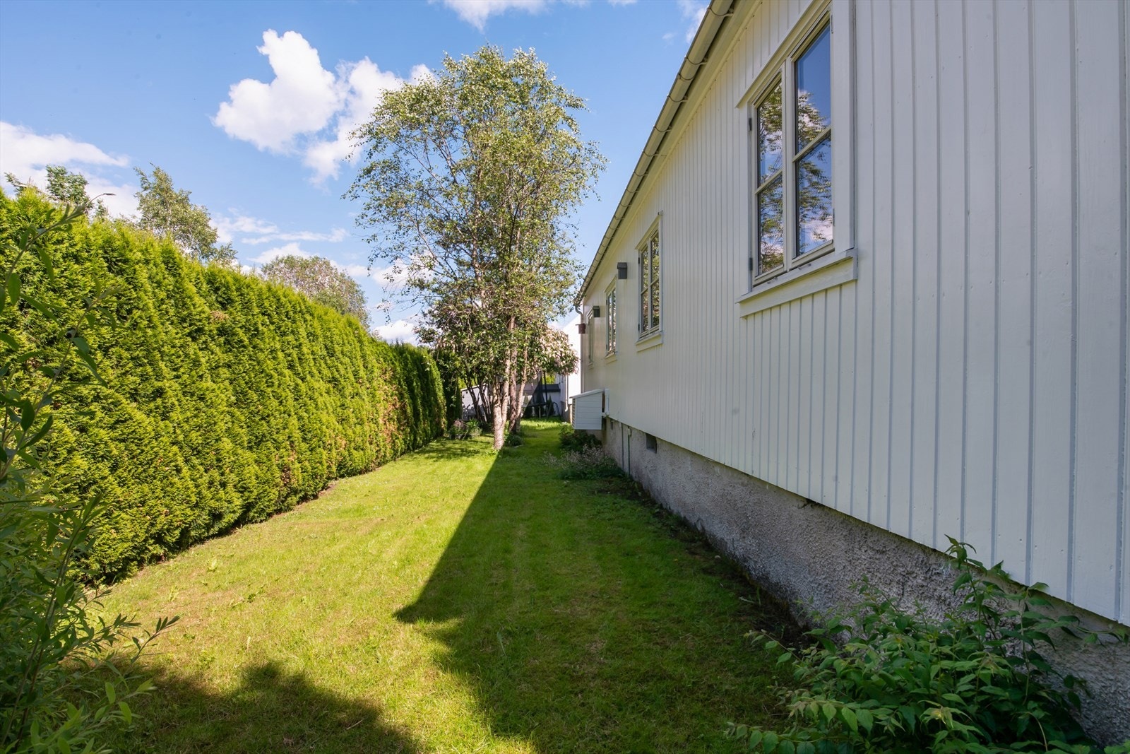 Solrikt og pent opparbeidet eiendom med asfaltert gårdsplass, plenarealer, platting og div. beplantninger m.m Galleribilde