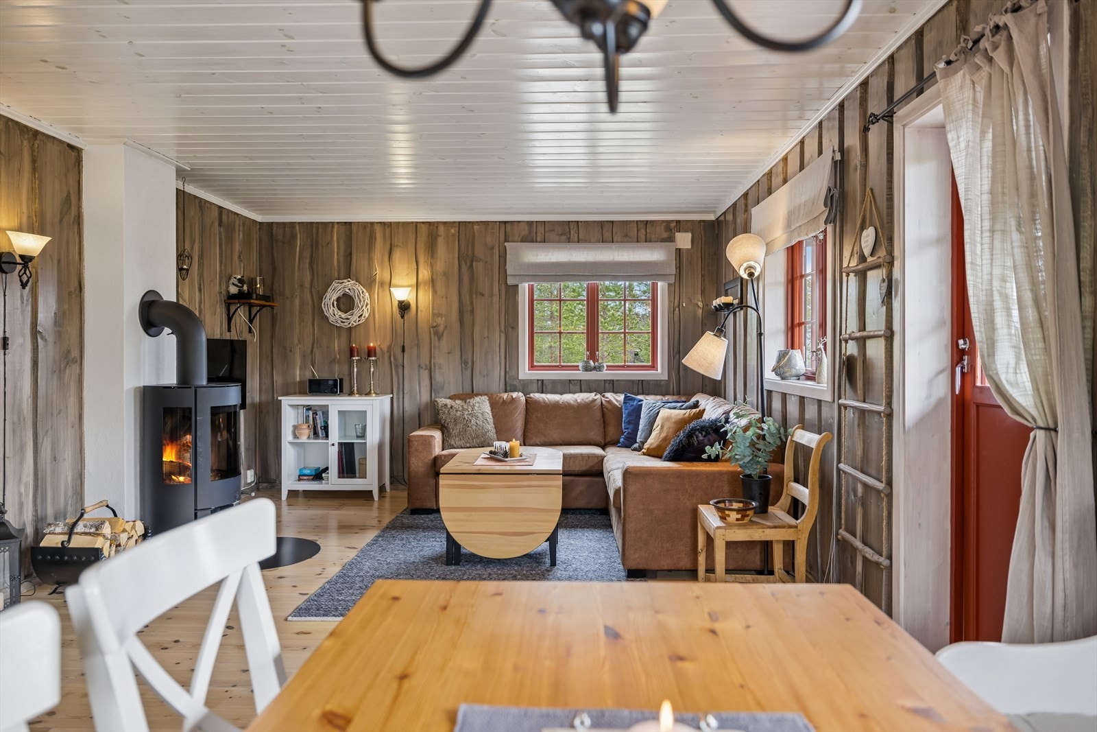 Vinduene med koblede glass og faste sprosser rammer inn utsikten mot naturomgivelsene. Galleribilde