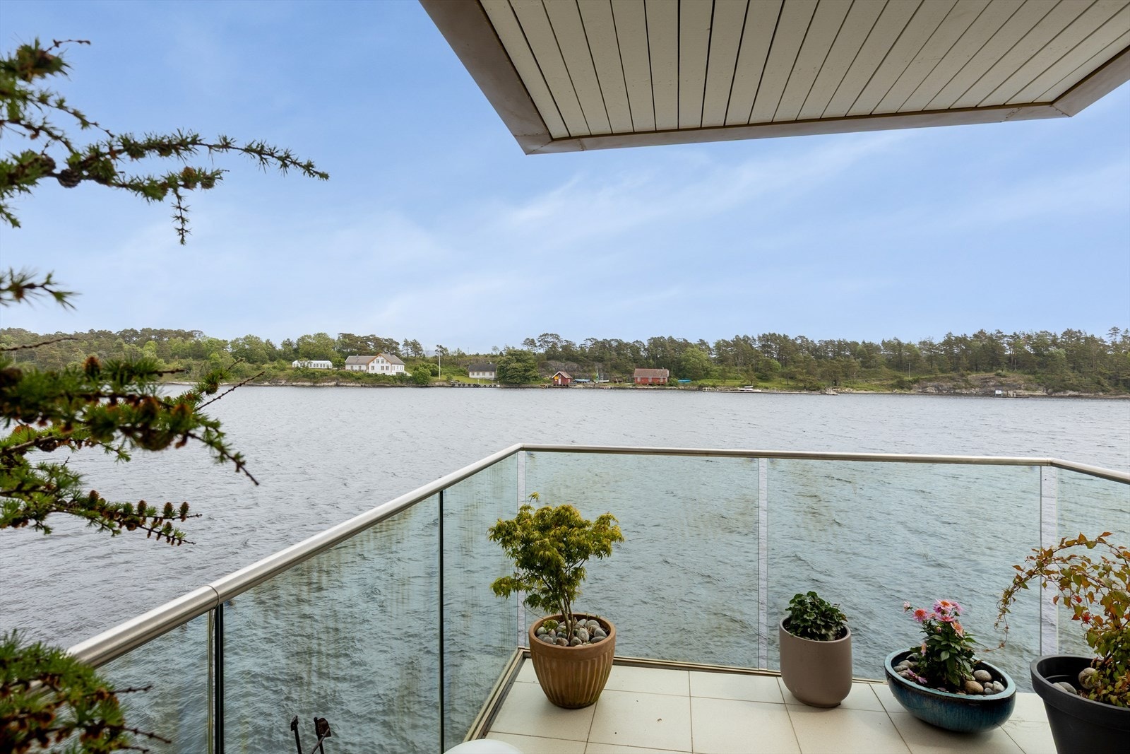 Boligen har to nydelige uteplasser med utgang fra stue og kjøkken. Verandaen mot nord har utgang fra stuen, og ligger høyt og fritt med åpen utsikt over sjøen. Galleribilde