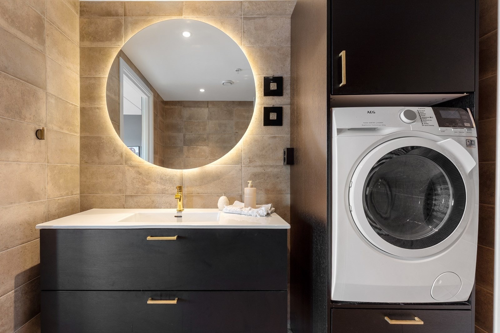 Badet har opplegg for vaskemaskin og vaskemaskinen er praktisk plassert i innredning med skap for oppbevaring. Det er varmekabler i gulv og balansert ventilasjon. Galleribilde