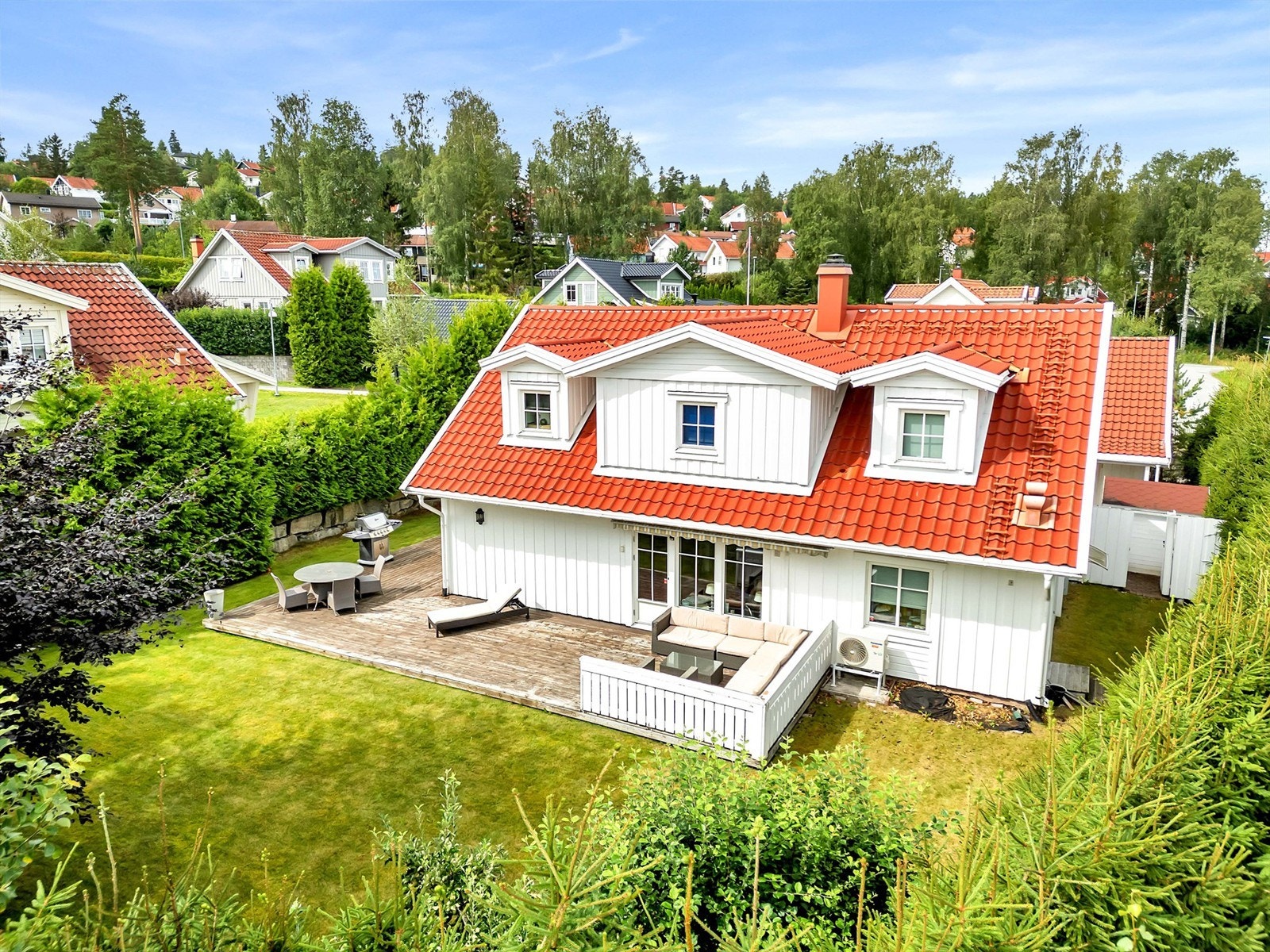 Velholdt uteområde med solrik terrasse, plen og skjermede soner rundt boligen. Galleribilde