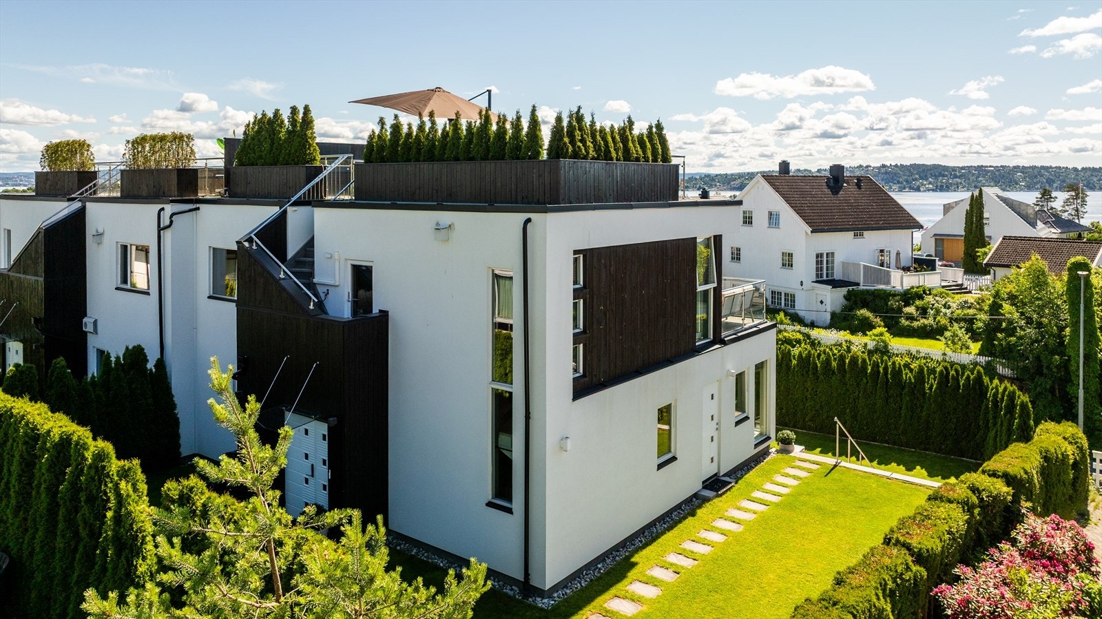Hovedinngang fra baksiden av huset, hyggelig grønn gressplen med god plass. Galleribilde