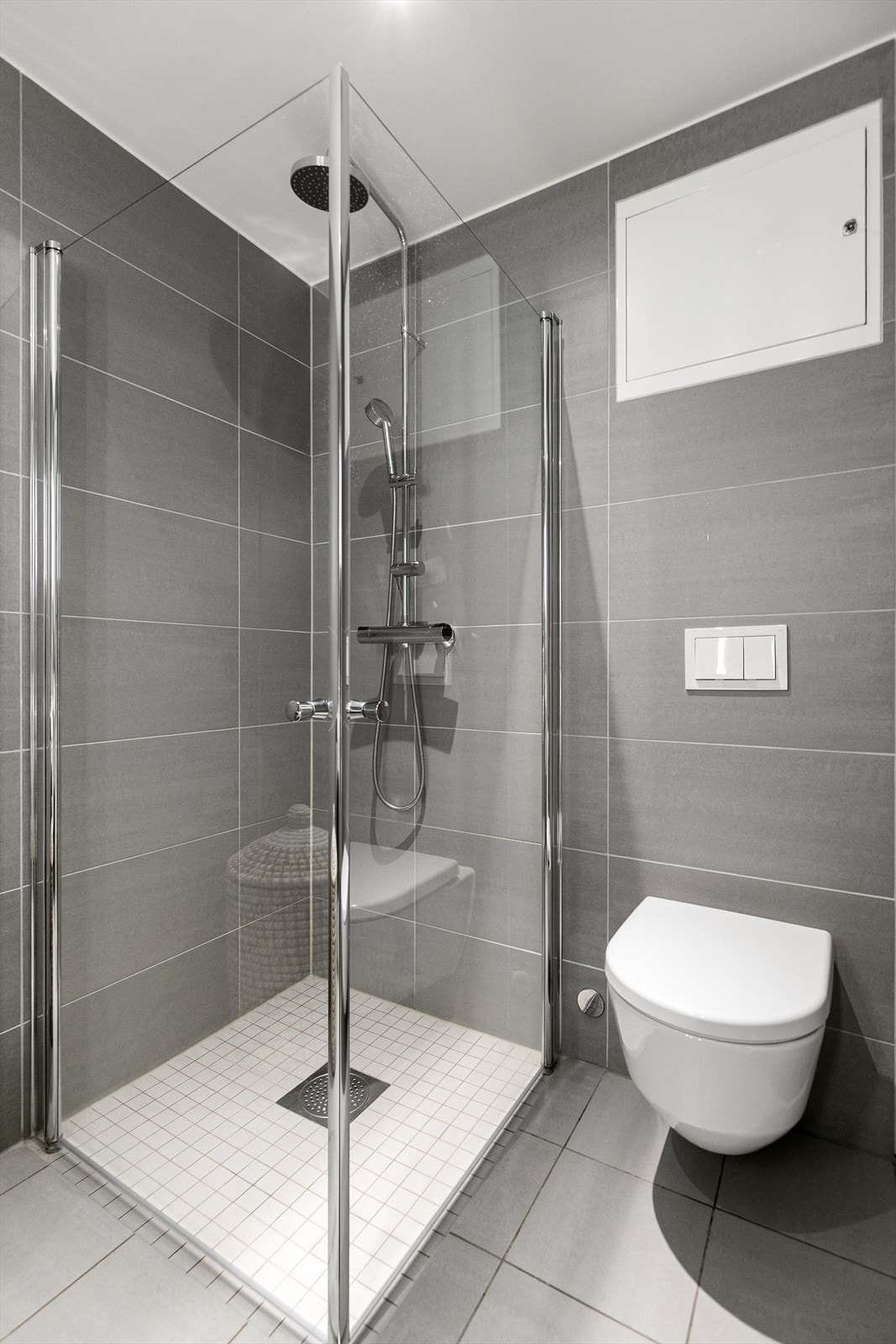 Badet er innredet med servantinnredning med nedfelt servant, vegghengt toalett og dusjhjørne med glassvegger. I tillegg er det opplegg for vaskemaskin, noe som bidrar til en praktisk og funksjonell romløsning. Galleribilde