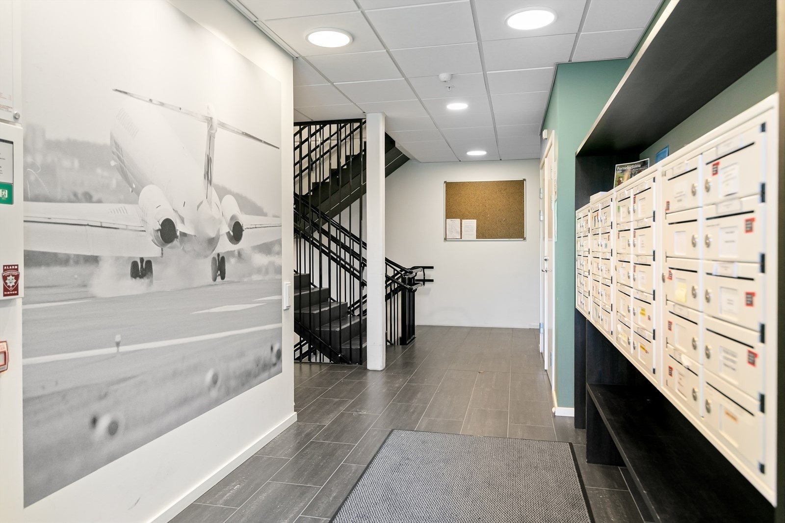 Et pent og velordnet inngangsparti med postkasser og heis bidrar til et innbydende førsteinntrykk for både beboere og besøkende. Galleribilde