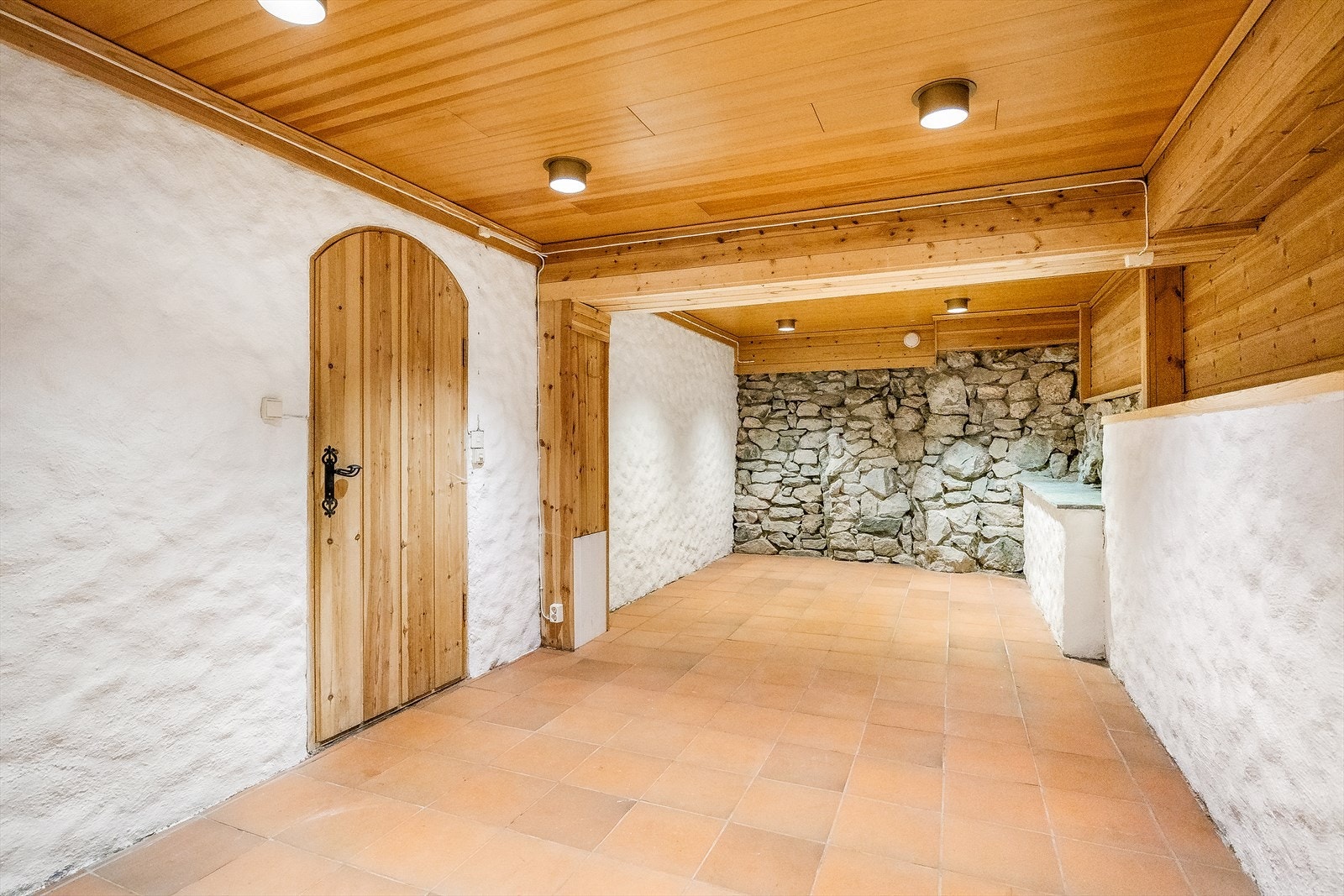 Innredet rom i underetasjen med flislagt gulv og naturstein på deler av veggen. Dette rommet var i sin tid bordtennis rom. Her har familien mange minner fra! Galleribilde