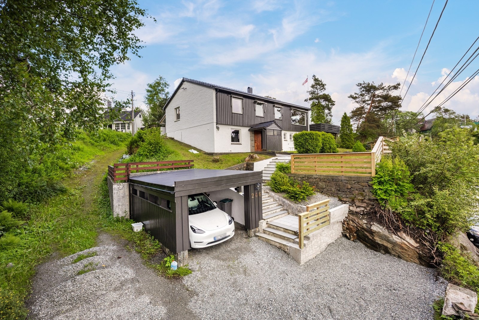Eiendommen har en carport på ca. 17 m² og ytterligere biloppstillingsplass på gruset gårdsplass. Galleribilde