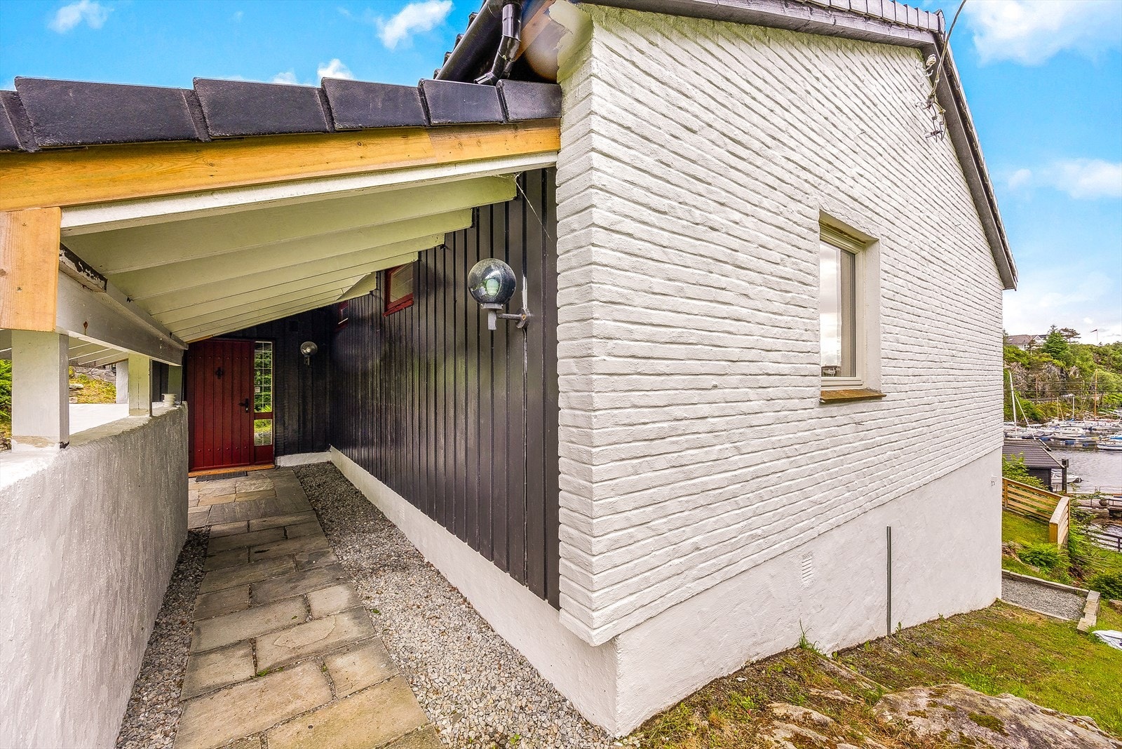 Fasaden er en kombinasjon av malt teglstein og trepanel. Taket er tekket med betongstein. Galleribilde