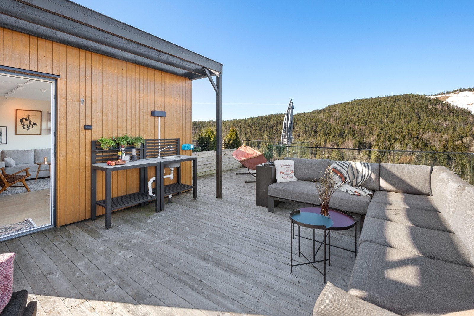 Takterrassen har også et lite utekjøkken med benkeplass, stikkontakt og vask. Det er impregnerte terrassebord og rekkverk i stål, glass og tre Galleribilde