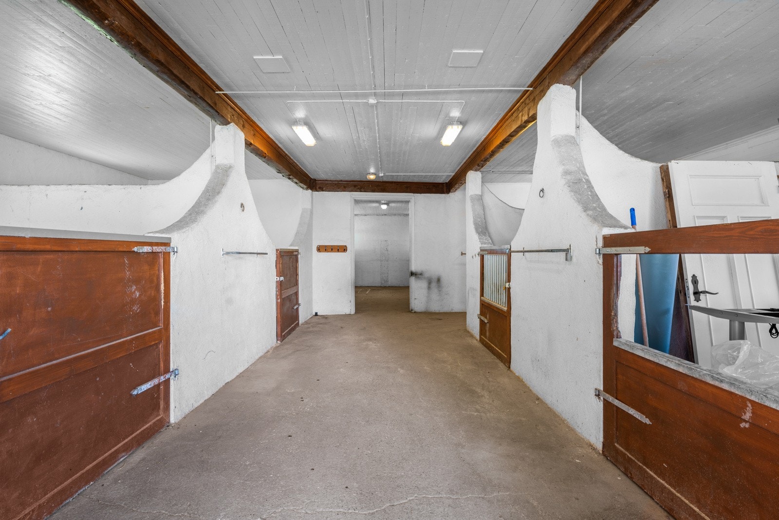 Stall med 11 stallplasser med støpte vegger mellom boksene og en takhøyde på 2,85 meter i den opprinnelige delen Galleribilde