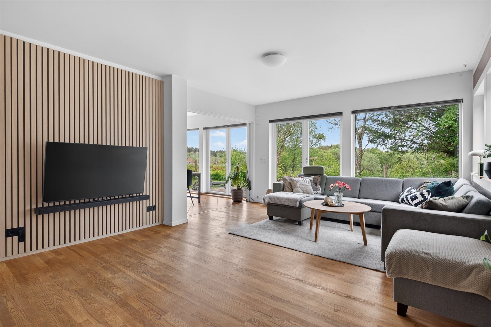 En stilren spilevegg i tre definerer TV-sonen og tilfører rommet en moderne og varm karakter. Galleribilde