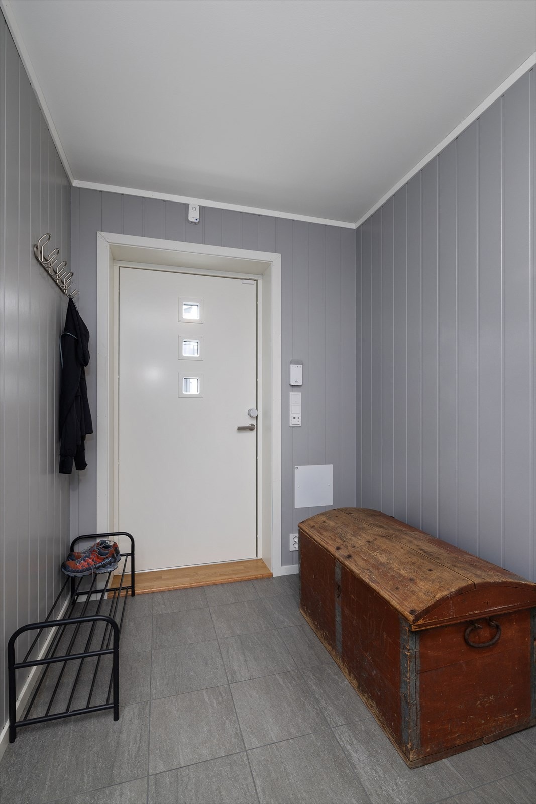Entré med flislagt gulv og plass til oppbevaring av yttertøy og sko. Galleribilde