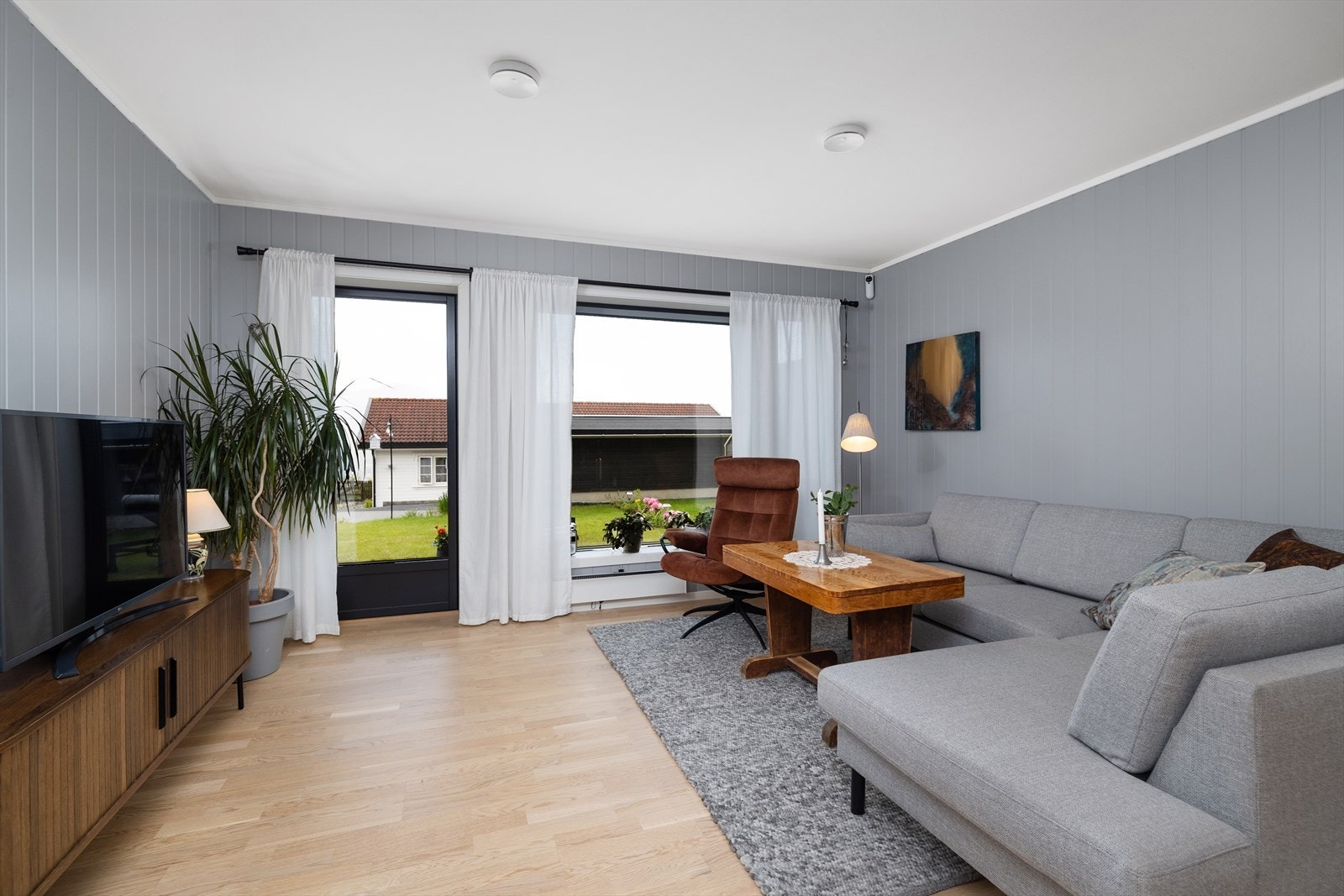 Store vindusflater og utgang til terrassen gir rikelig med dagslys i oppholdsrommet. Galleribilde