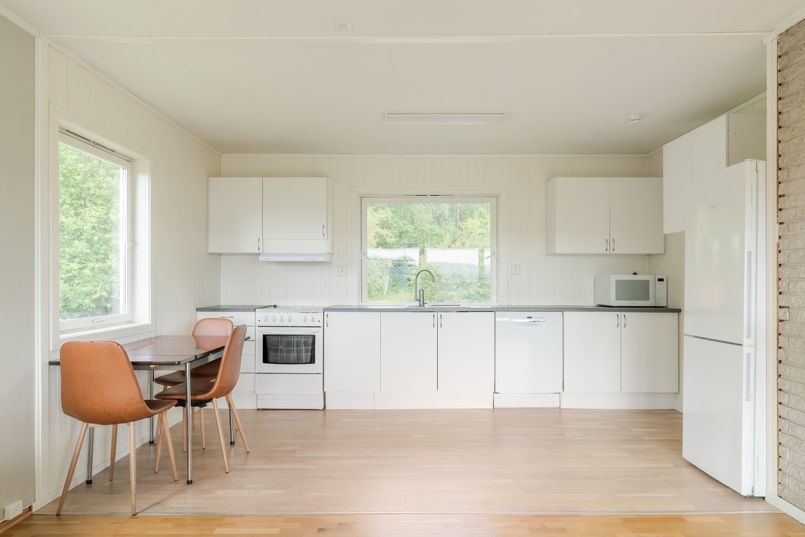 Kjøkkenet har innredning med glatte fronter og en slitesterk benkeplate i laminat. Galleribilde