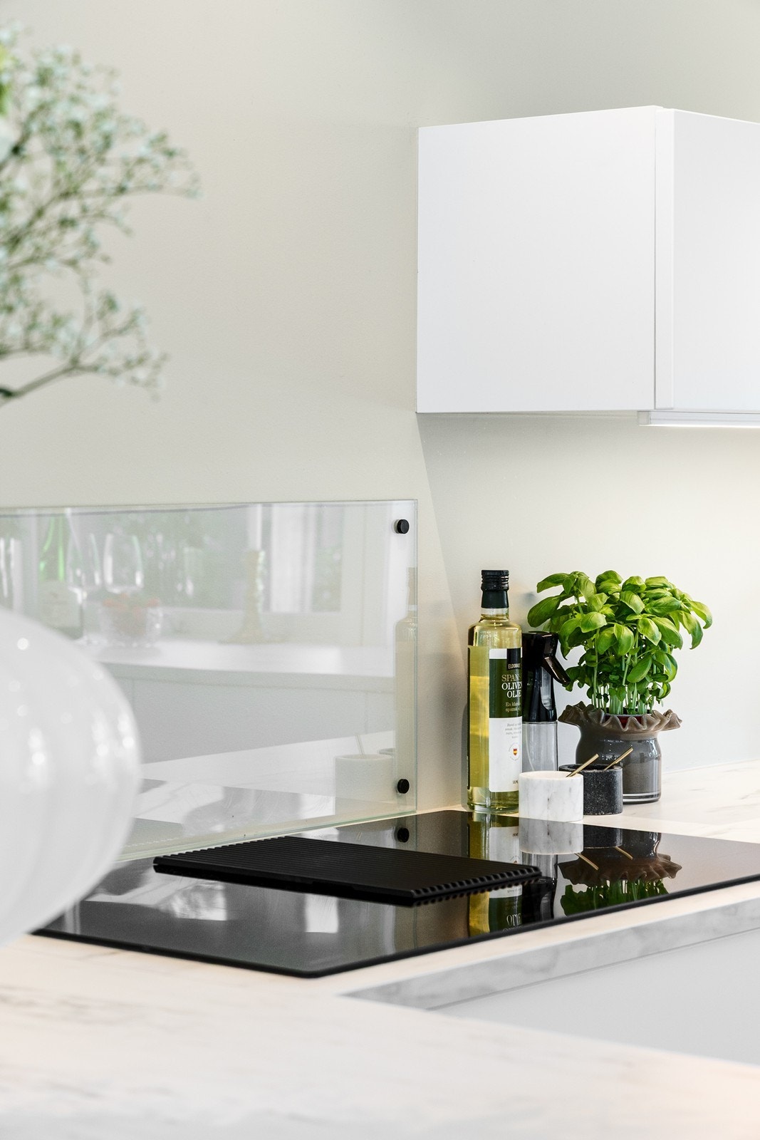 Integrert induksjonsplatetopp med ventilasjon. Backsplash i glass i bakkant av platetoppen. Galleribilde