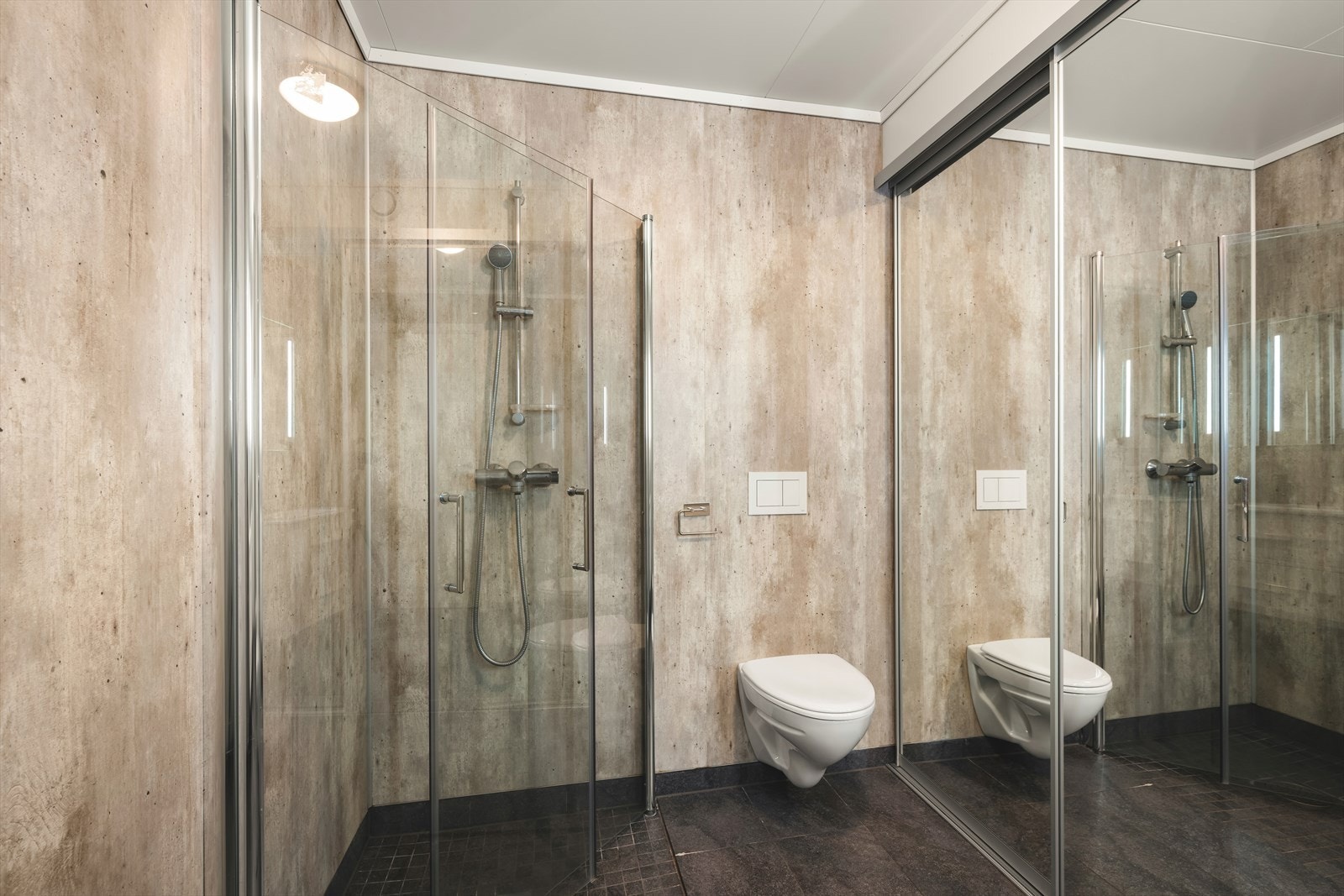 Badet har flislagt gulv, baderomsplater på veggene og malt himling. Rommet er innredet med servant i baderomsinnredning, vegghengt toalett, dusjløsning med dusjvegger samt opplegg for vaskemaskin. Galleribilde