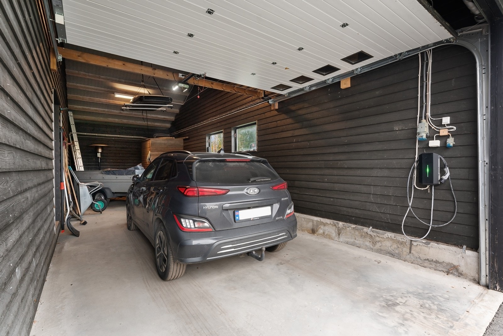 Garasjeplass med elbillader og elektrisk port. Galleribilde
