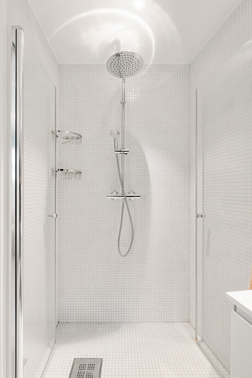 Det moderne badet er utstyrt med dusjnisje med innfellbare glassdører, behagelig gulvvarme og klosett og downlights. Galleribilde