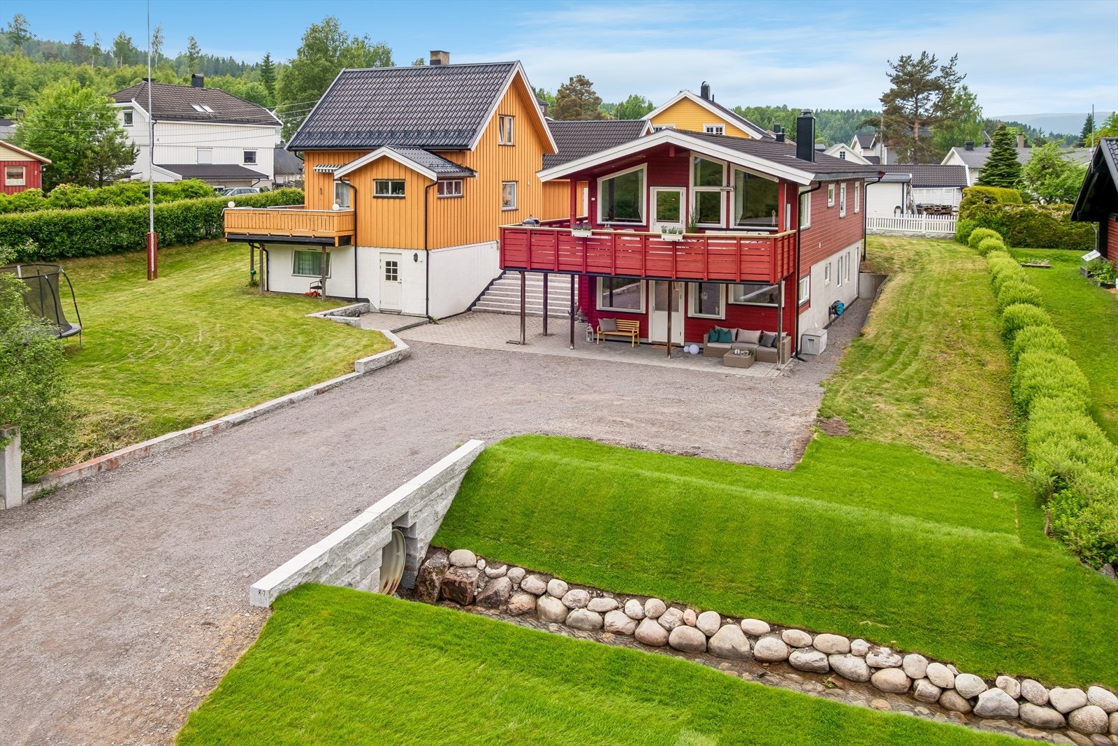 Tomten er opparbeidet med store plenarealer og gruset gårdsplass. Det går en bekk over eiendommen Galleribilde