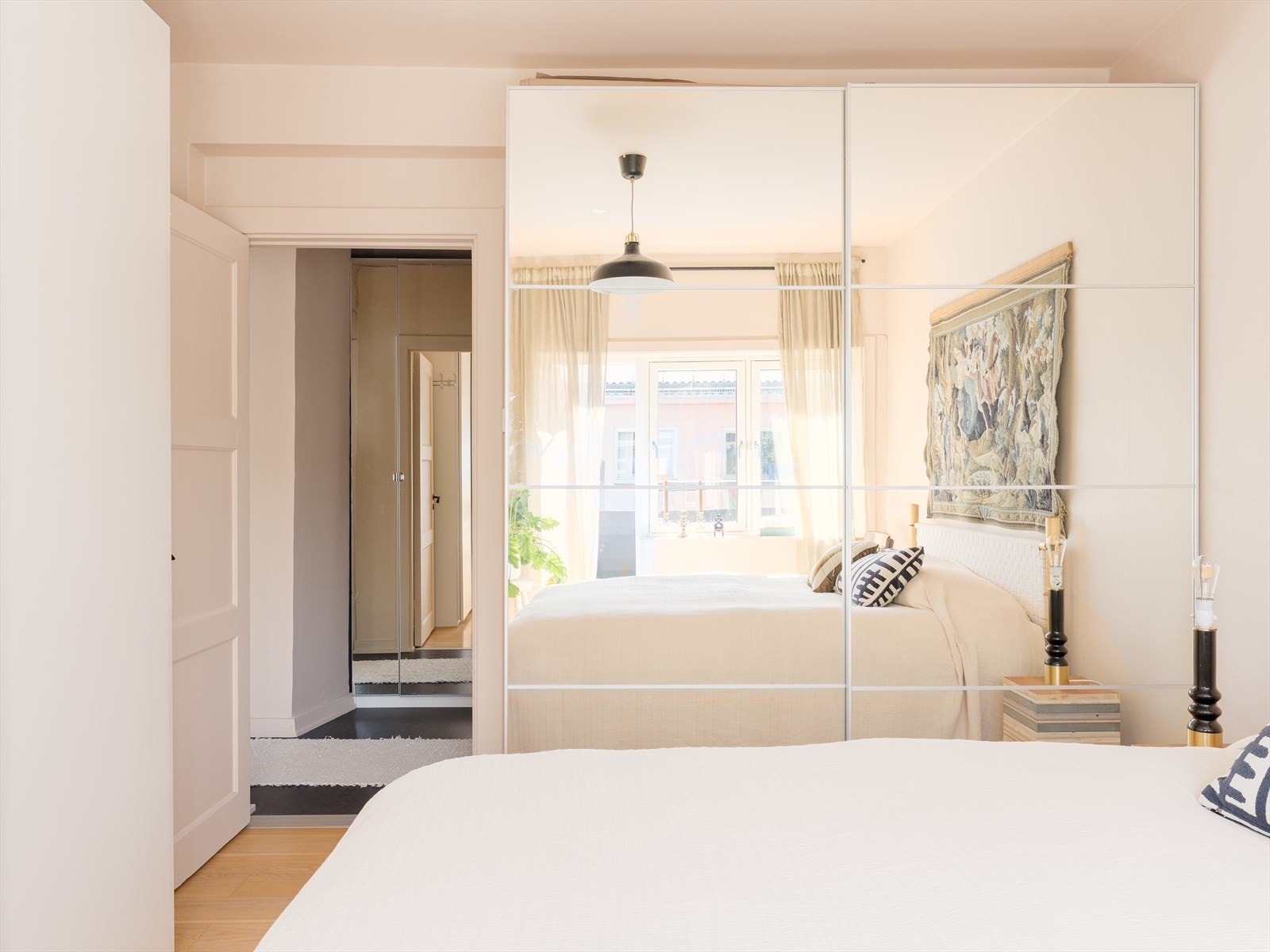 Stor skyvedørsgarderobe med speilfronter langs den ene veggen og garderobeskap langs den andre. Galleribilde