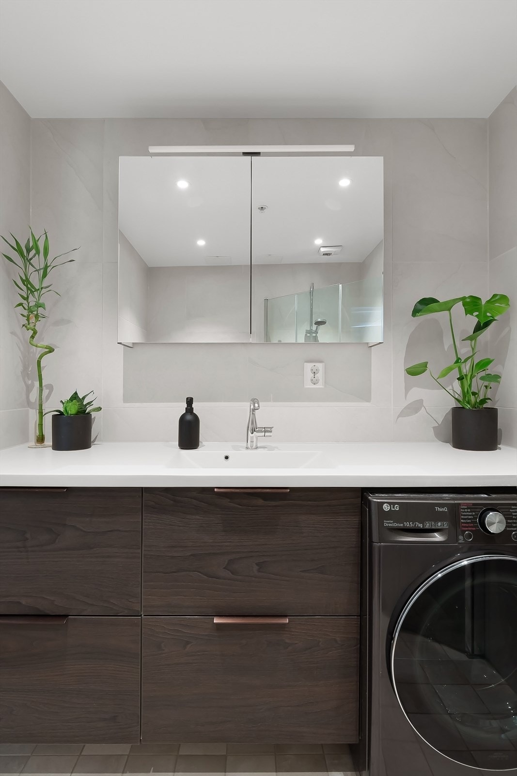 Badet består av dusjhjørne med innfellbare glassdører, servant, vegghengt toalett, opplegg for vaskemaskin og mekanisk avtrekk. Galleribilde