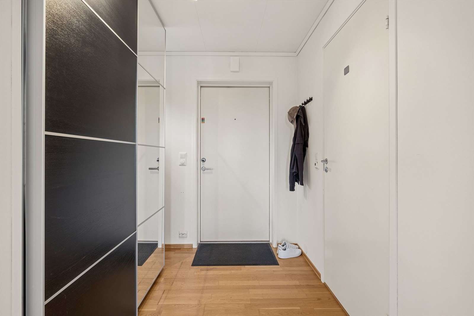 Entré med plass til yttertøy og en romslig skyvedørsgarderobe med speilfronter. Galleribilde