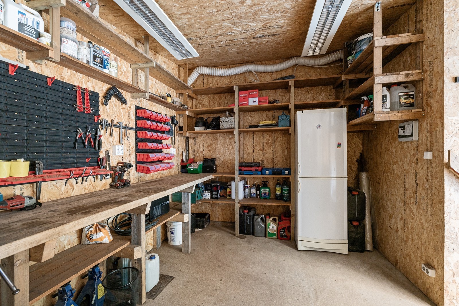Arbeidsområdet er utstyrt med hyller og benker som gir praktiske oppbevaringsmuligheter. Galleribilde