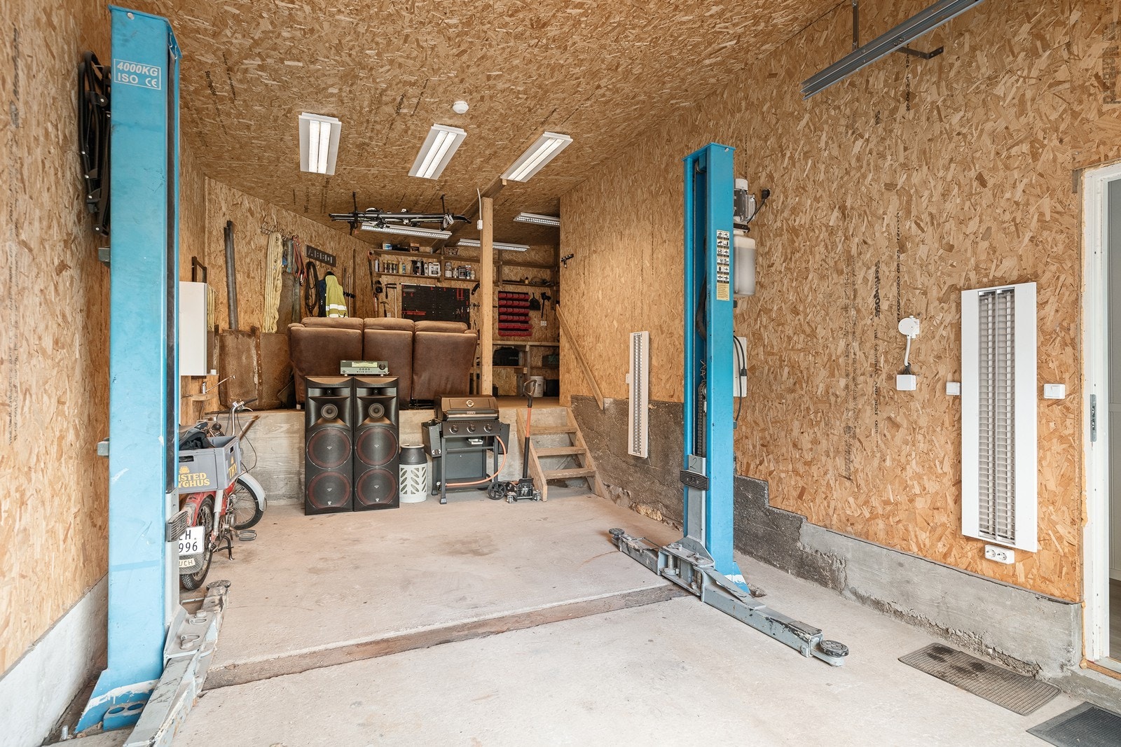 Garasjen har en romslig utforming med plass til både kjøretøy og arbeidsutstyr. Galleribilde