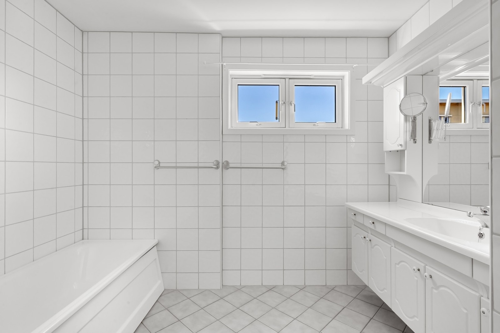 Badet er utstyrt med badekar, dusjhjørne, stor baderomsinnredning og gulvstående wc Galleribilde