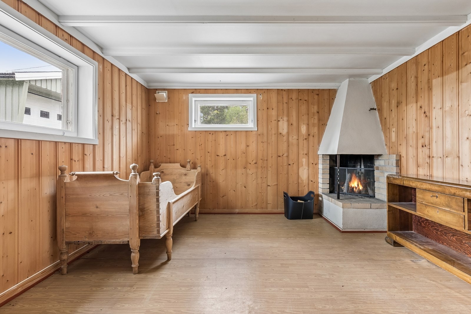 Kjellerstue med panel på veggene og åpen peis. på grunn av fuktig klima anbefales ikke rommet til opphold. Galleribilde
