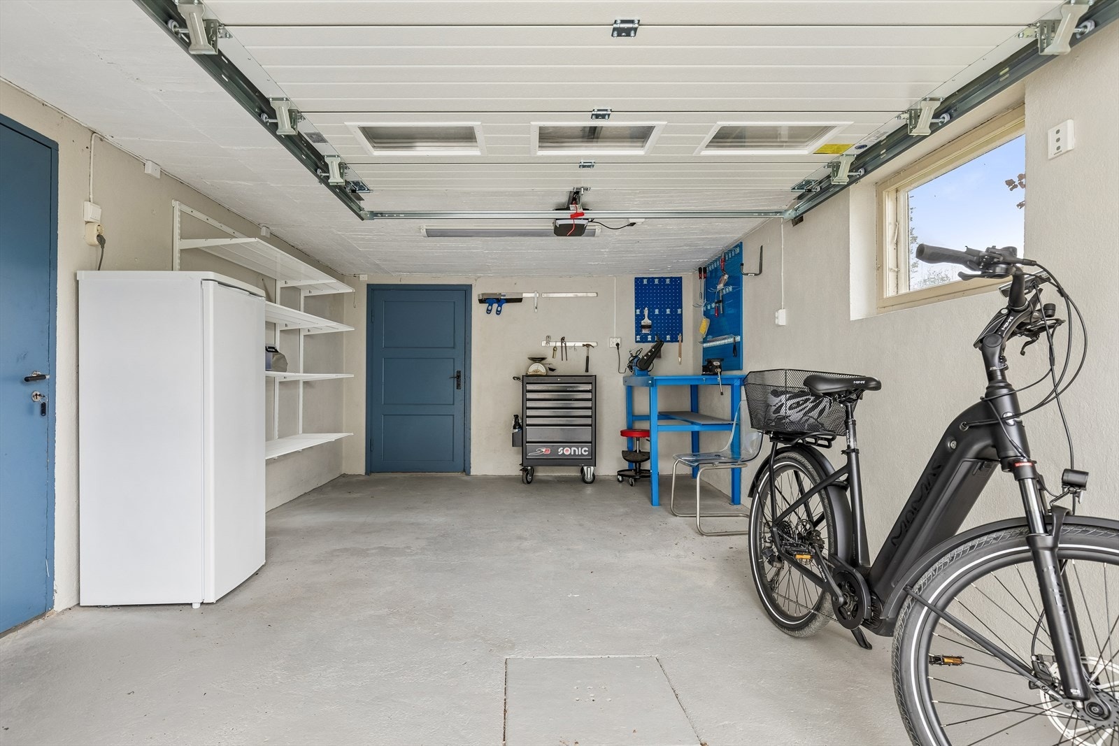 Garasje integrert i kjelleren med motorisert ledport. Galleribilde