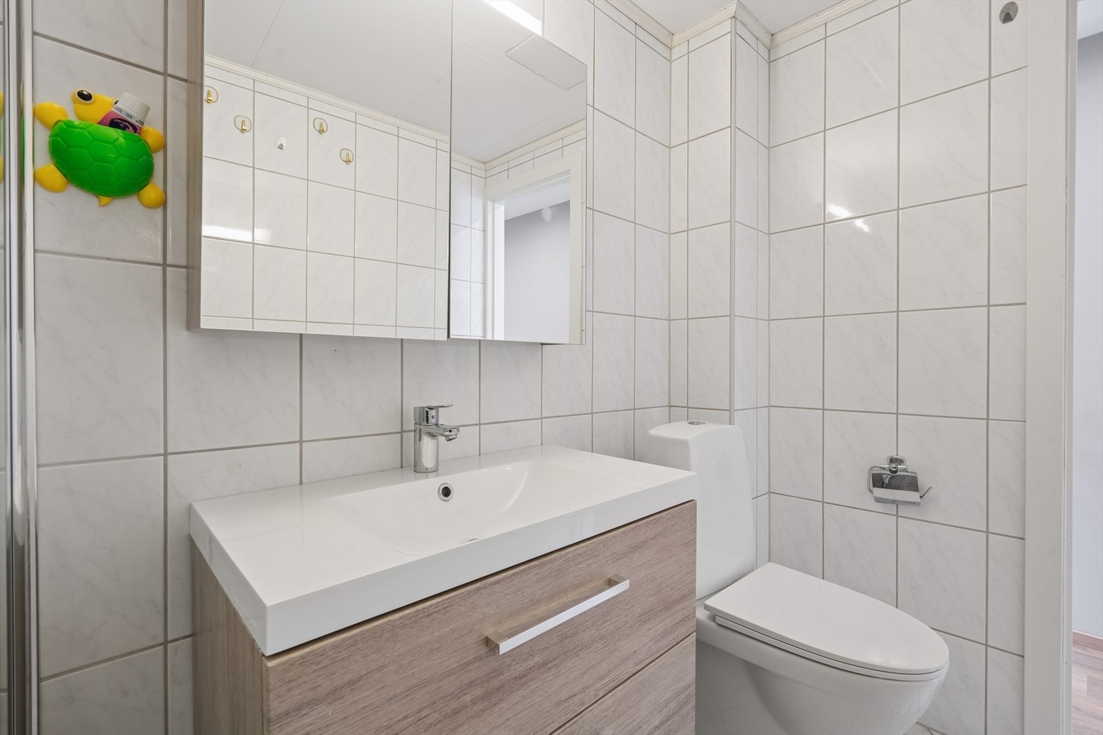Badet har gulvstående toalett og en praktisk hånddusj ved siden av. Galleribilde