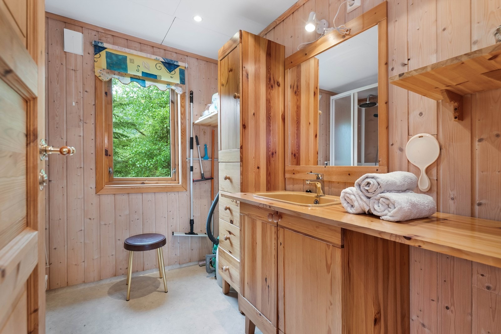 Badet er innredet med servant, oppbevaringsløsninger og har vinylbelegg på gulvet. Galleribilde