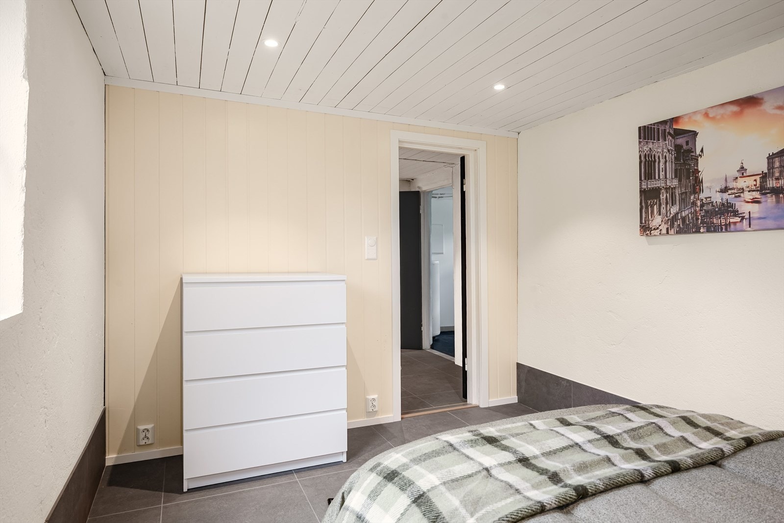 Soverommet har store fliser på gulv med gulvvarme, downlights i himlingen og overflater med lysmalt mur kombinert med lyse panelplater. Galleribilde