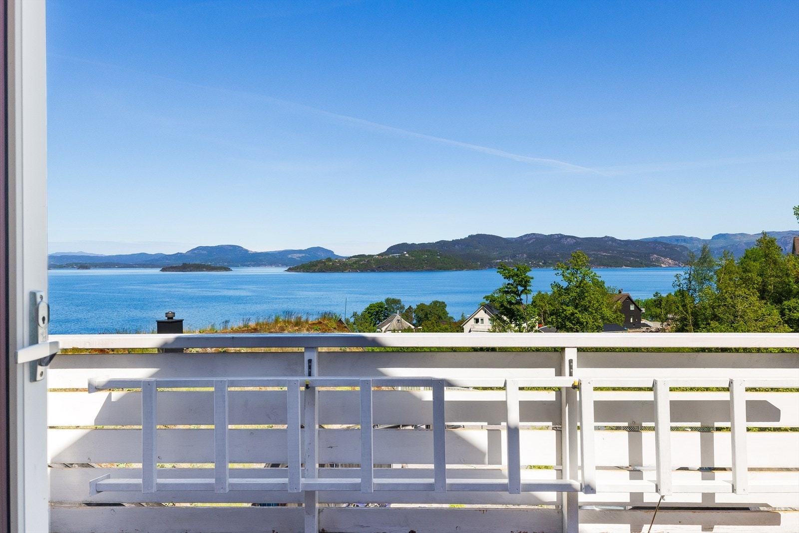 Nyt utsikten over sjø og landskap fra balkon på loft. Galleribilde