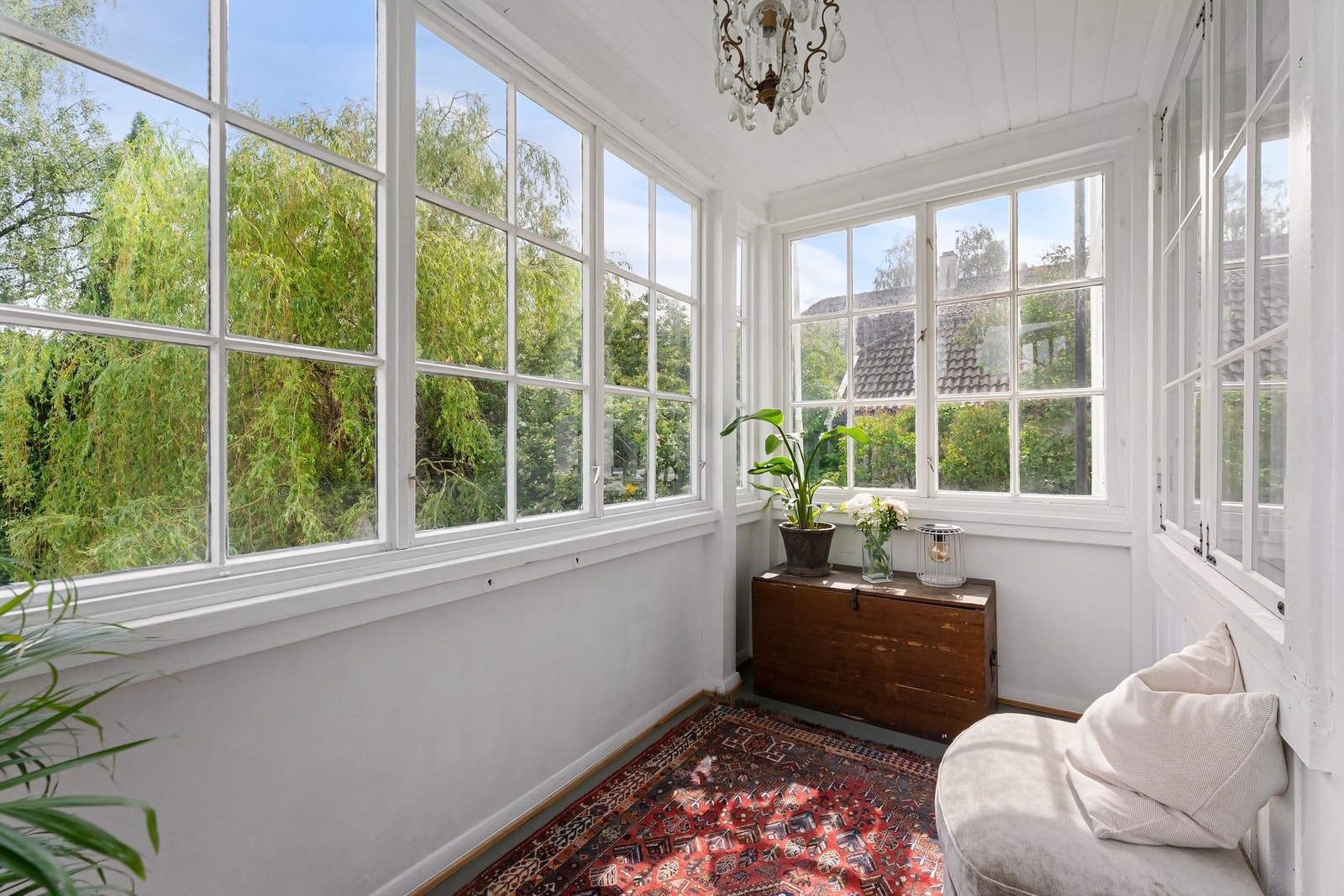Innglasset veranda med utgang fra stuen, et lunt uterom som forlenger sesongen. Galleribilde