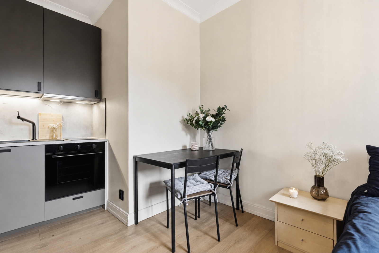 Planløsningen gir plass plass til både sovesofa, stuebord og en mindre hyggelig spisegruppe. (Ovnen er AI redigert) Galleribilde